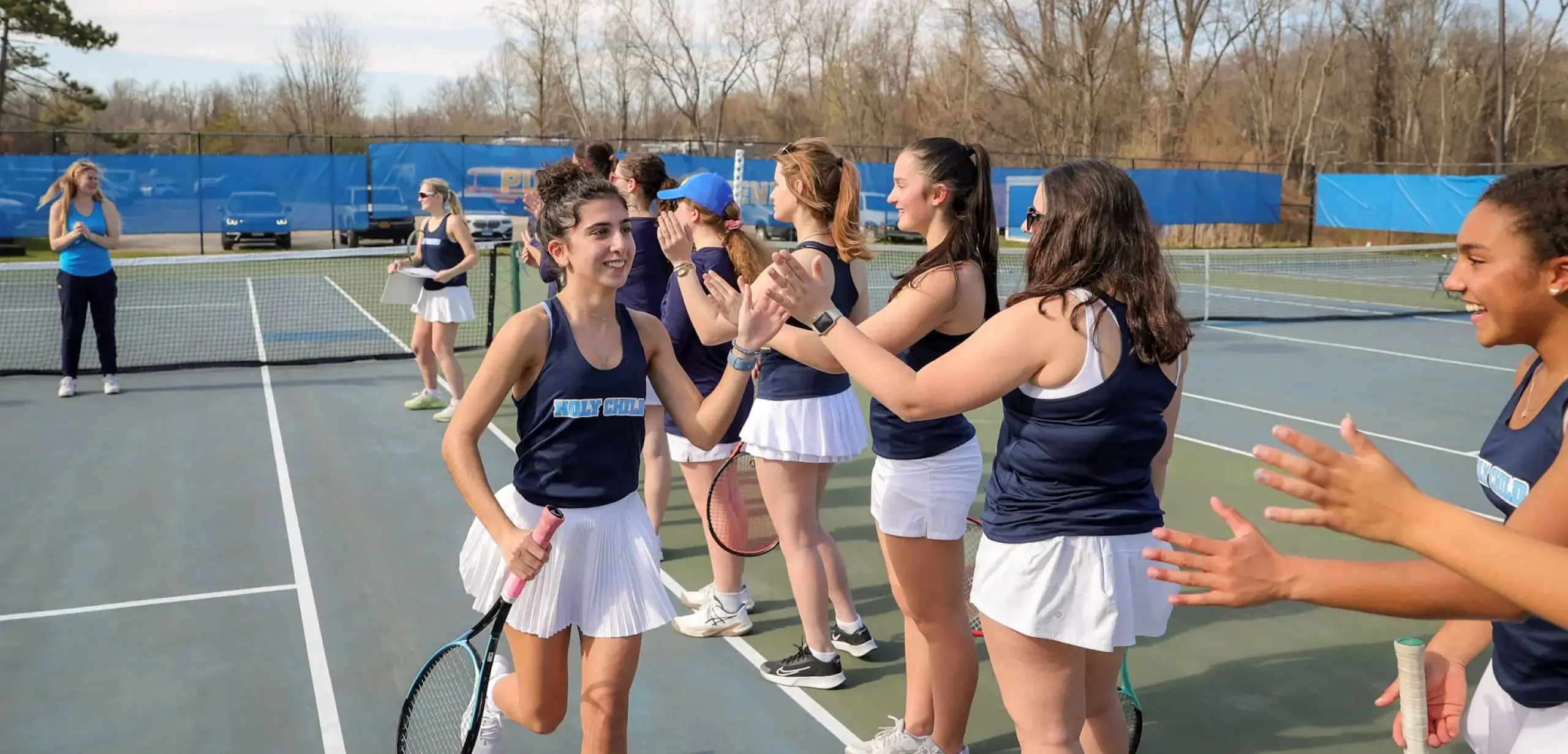 Students celebrating together on a tennis court