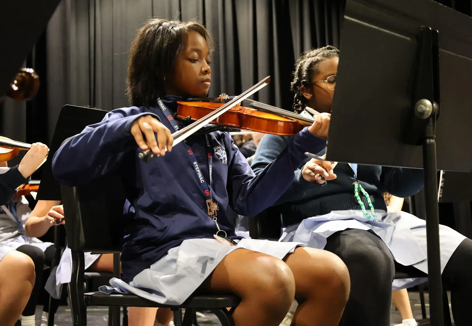 Students playing the violin during practice