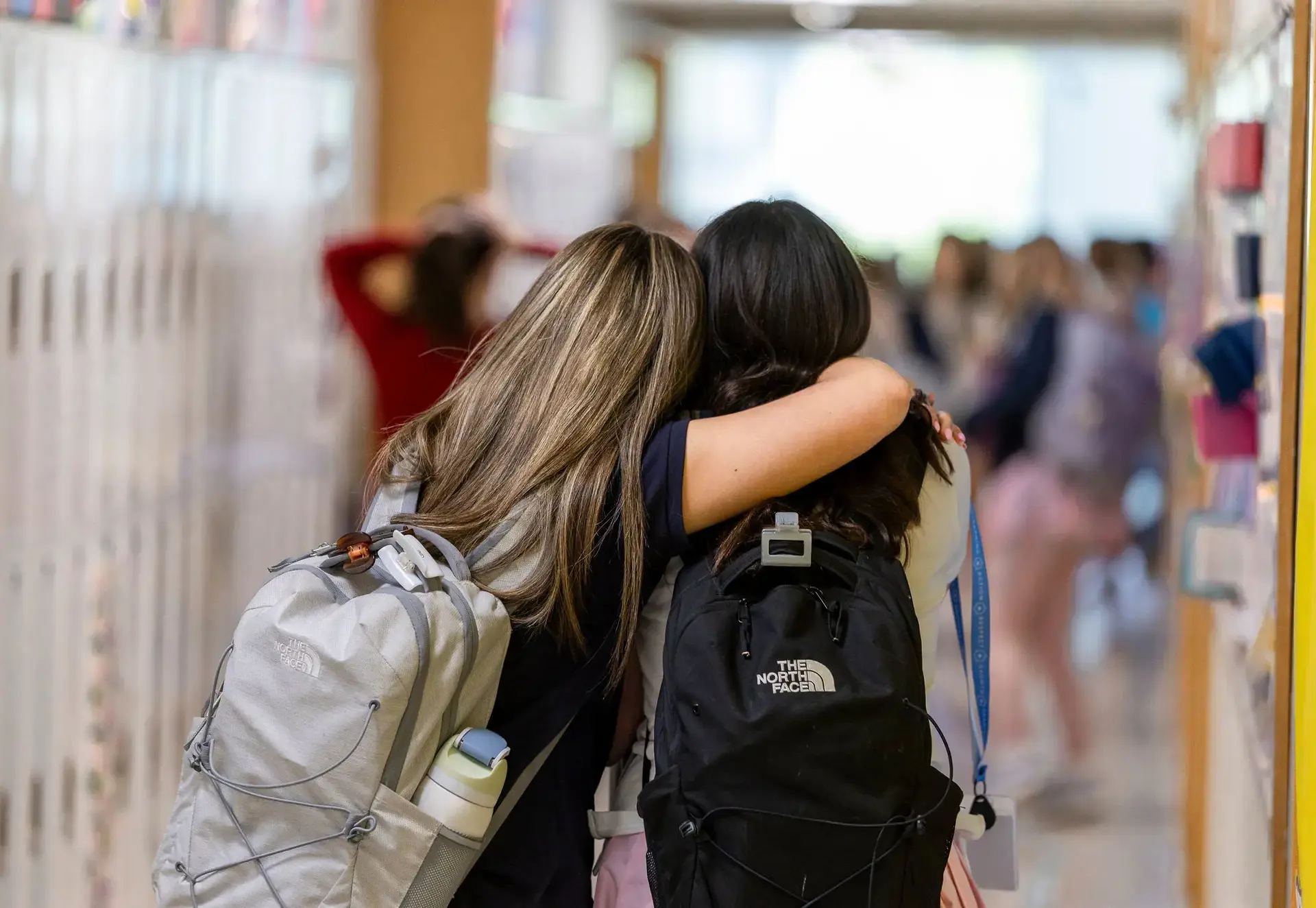 Student hugging a peer in the hallway