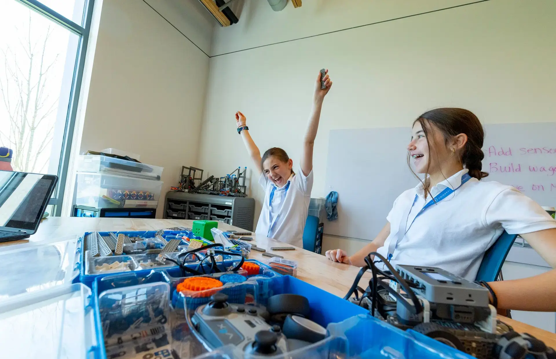 Students building and testing robotics equipment in a classroom