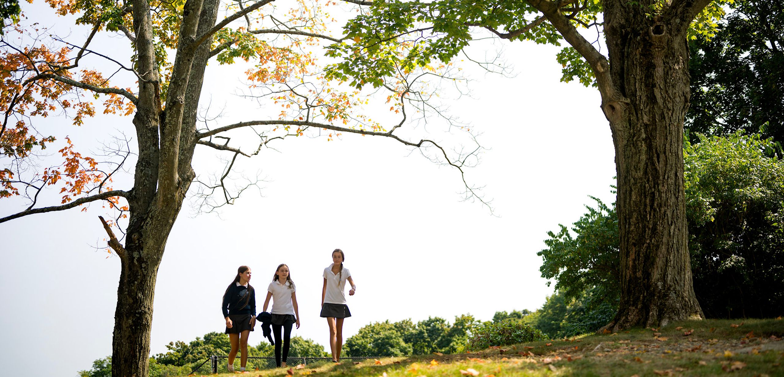 Upper School students walking outdoors.