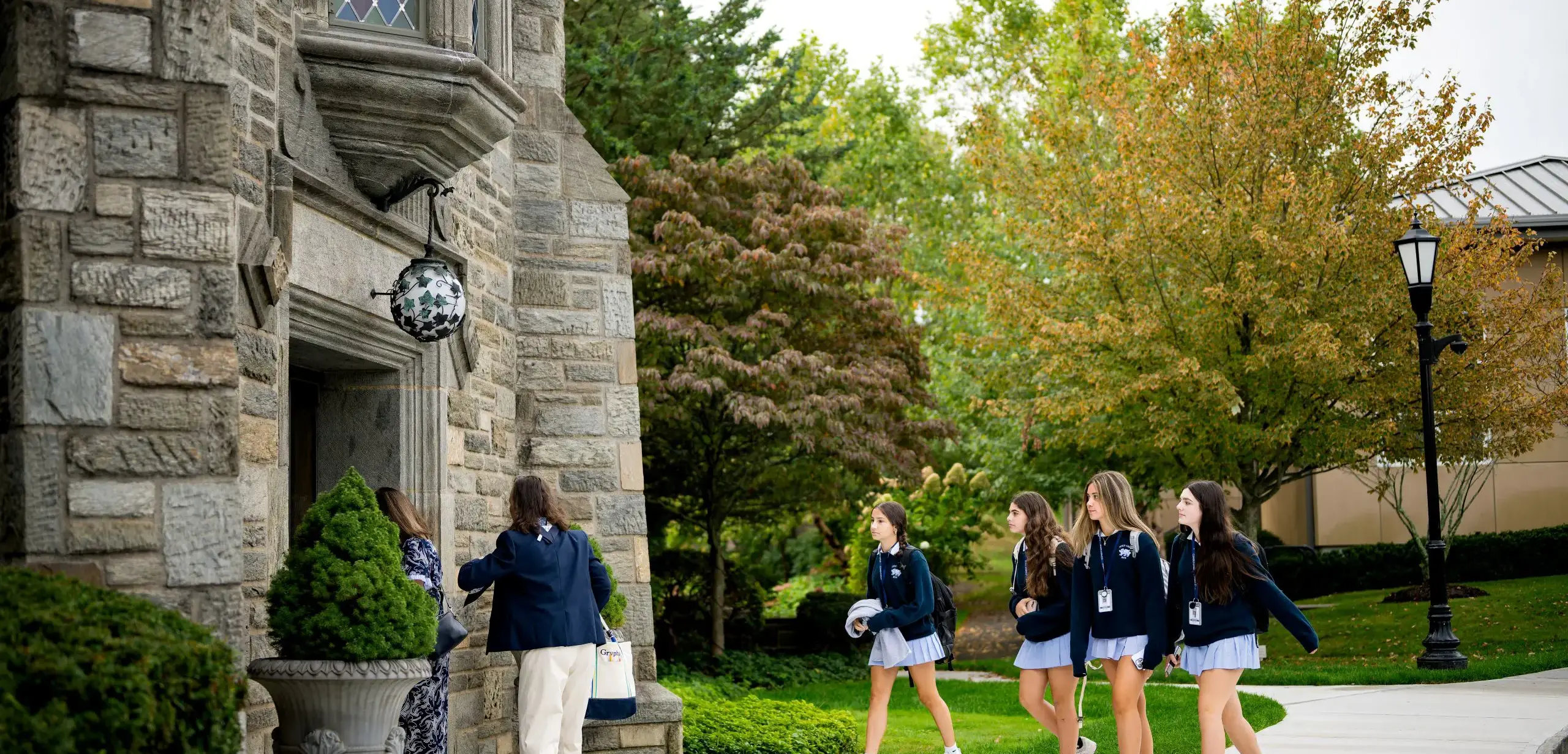 Holy Child students walking on campus into the Mansion.