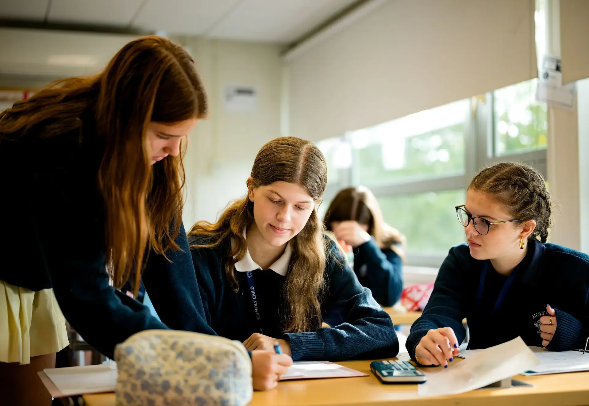 Student helping peers with a lesson