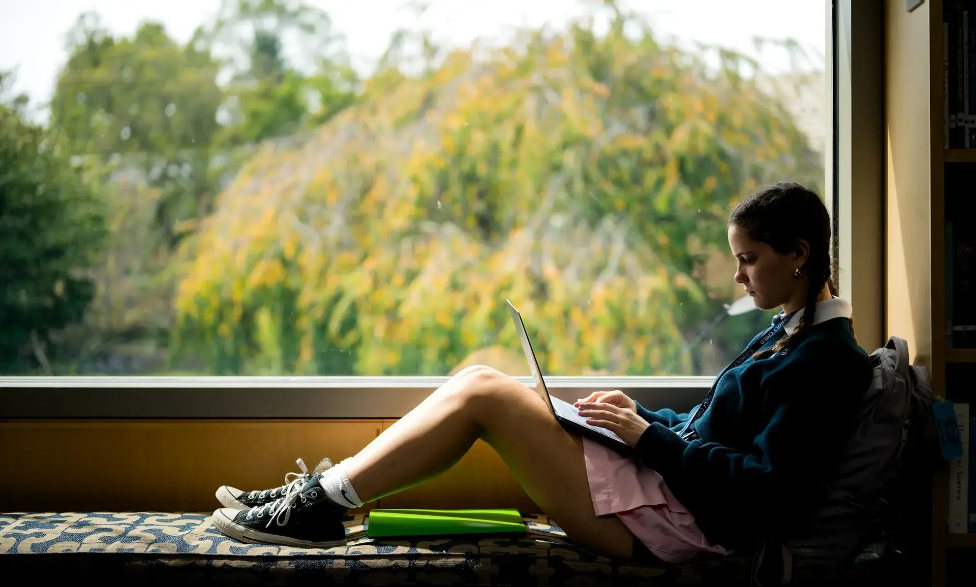 Student sitting next to a window studying